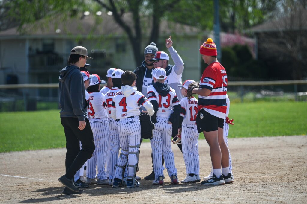 Youth baseball players gathered with coaches during team huddle – AE Training, Missouri